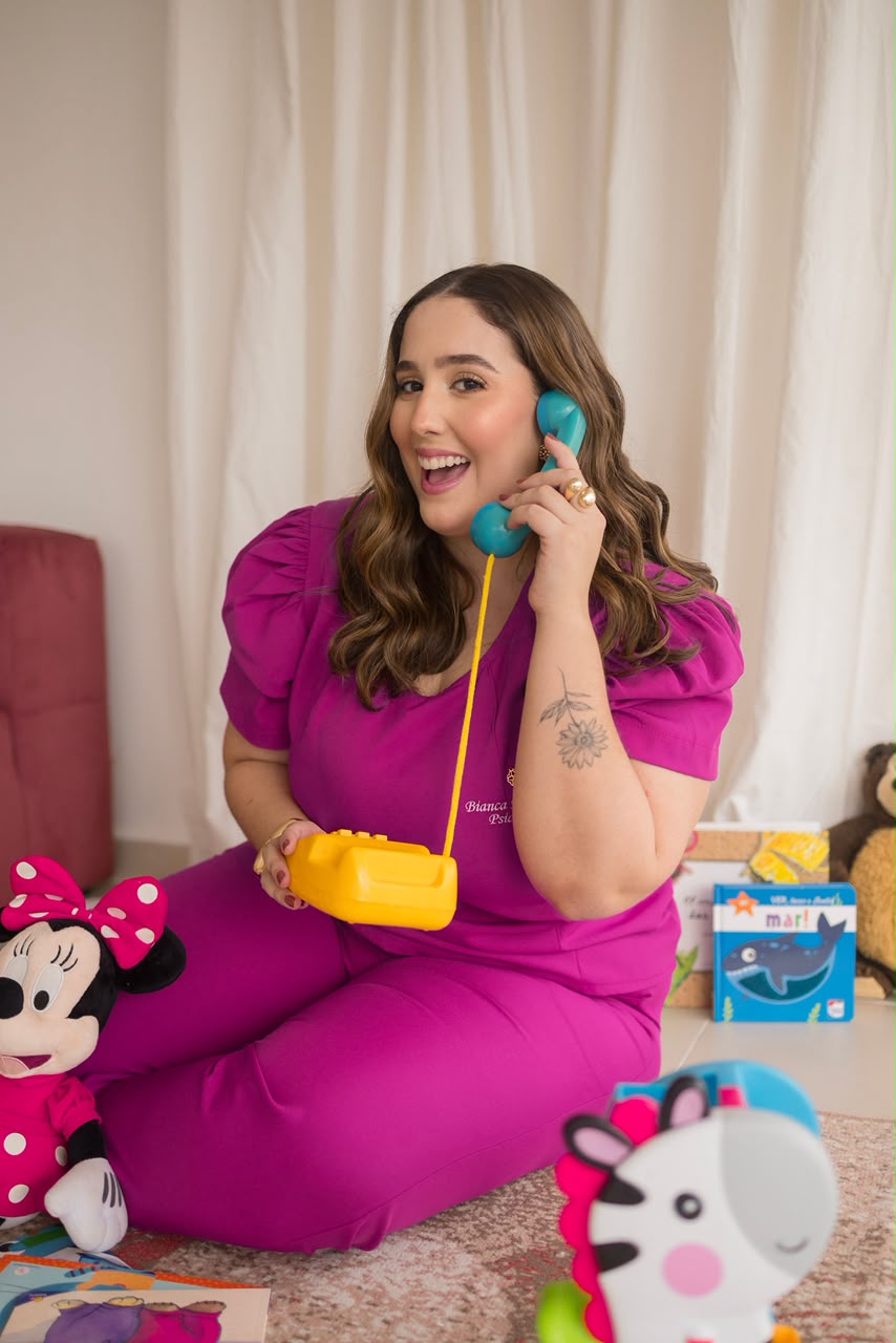 Bianca Mesquita brincando com telefone de brinquedo